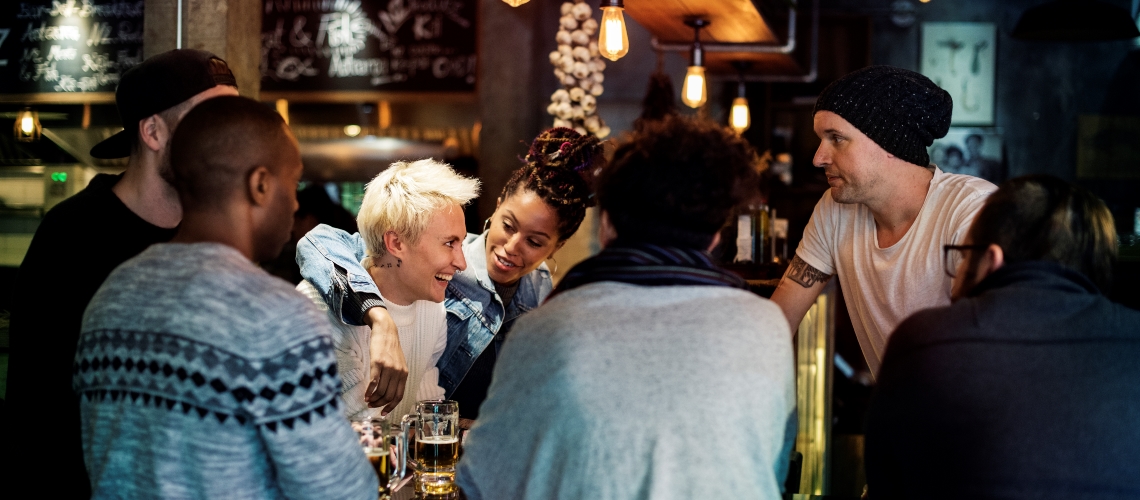 a group of people in a pub or restaurant all talking and laughing